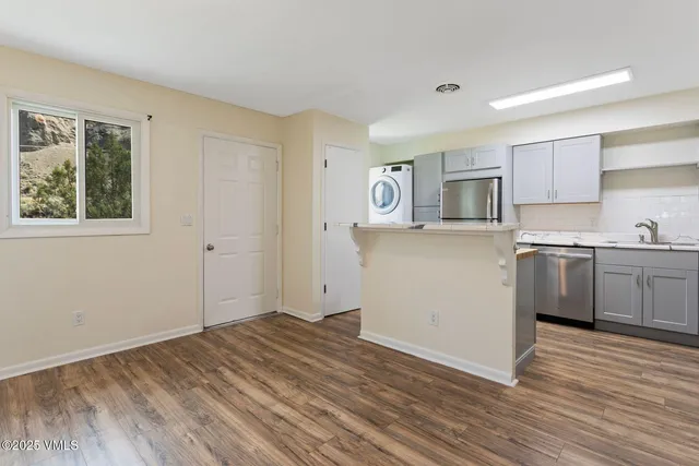 a view of a kitchen with wooden floor and electronic appliances