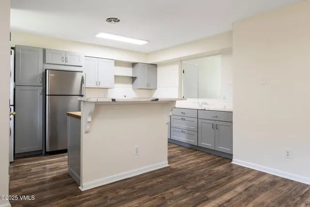 a kitchen with a sink a refrigerator and white cabinets