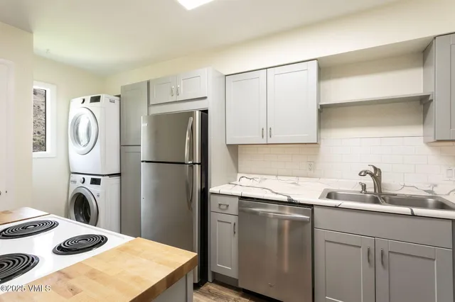 a kitchen with sink refrigerator and cabinets