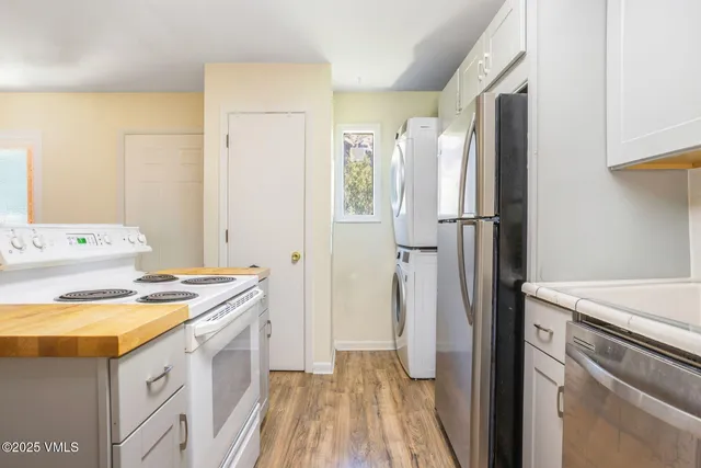 a kitchen with a refrigerator sink stove and cabinets