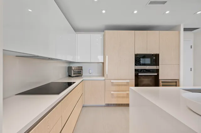 a kitchen with kitchen island a counter top stainless steel appliances and cabinets