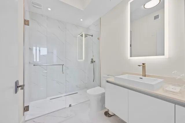 a bathroom with a sink a toilet and shower