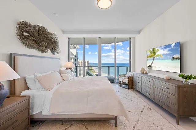 a bedroom with a bed a large window with outer view and couch