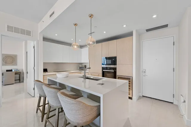 a kitchen with a sink a counter space appliances and cabinets