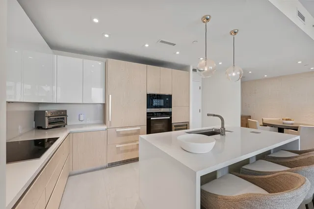 a kitchen with kitchen island a sink and a stove with wooden floor