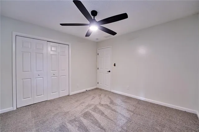 a view of a hallway with wooden floor and a bathroom