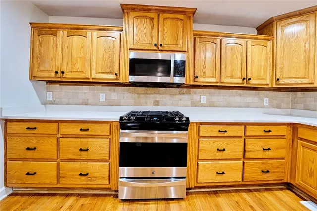 a front view of a house with a yard and trees