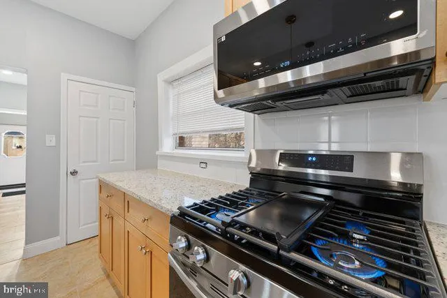 a stove top oven sitting inside of a kitchen