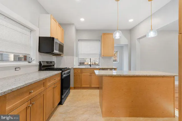 a kitchen with stainless steel appliances granite countertop a sink a stove top oven a counter space and cabinets