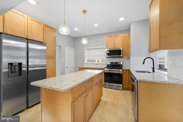 a kitchen with a sink a counter top space cabinets and stainless steel appliances