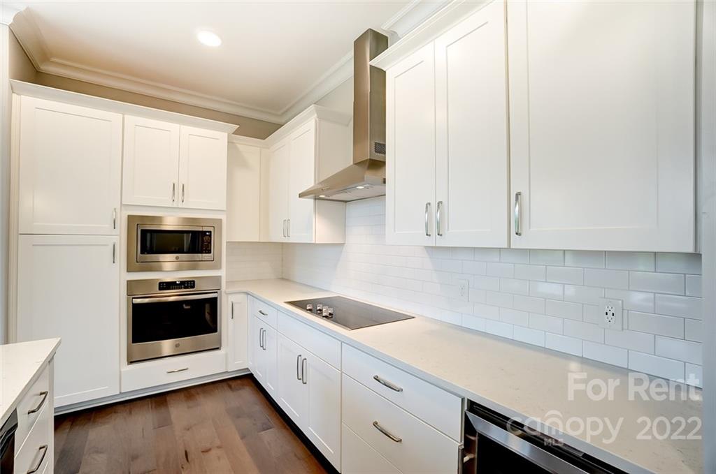 830 Providence Road, Unit 102 Charlotte, NC 28207 - Photo 12 of 31 a kitchen with granite countertop white cabinets and white appliances