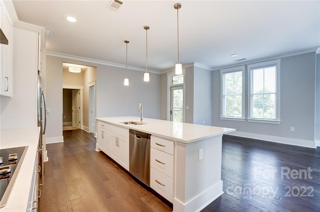 830 Providence Road, Unit 102 Charlotte, NC 28207 - Photo 14 of 31 a kitchen with a stove a sink a center island and wooden floor