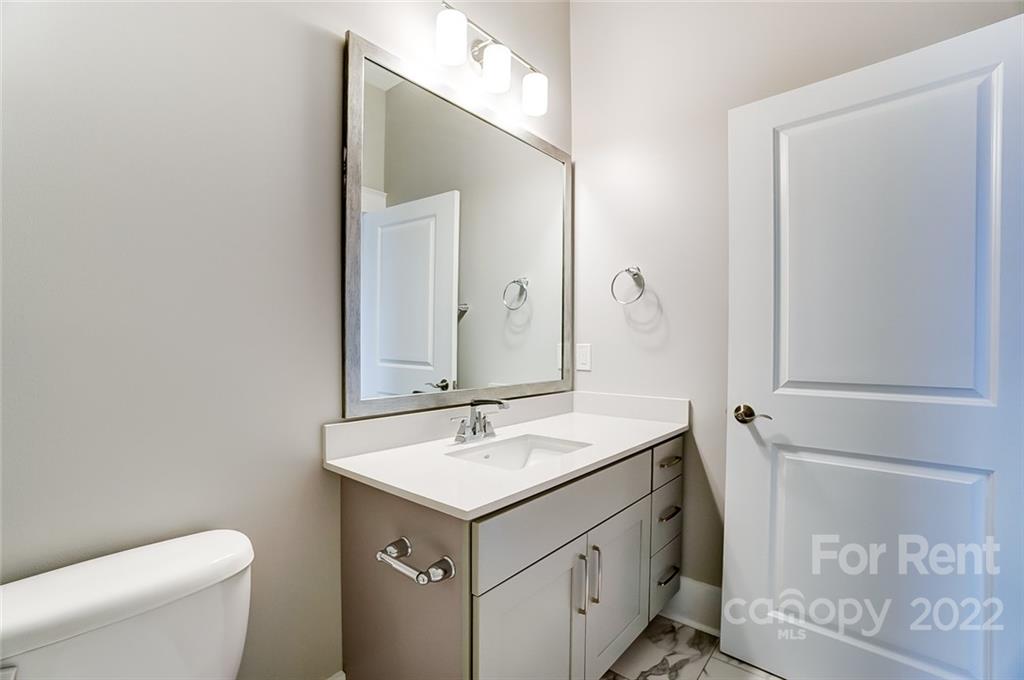 830 Providence Road, Unit 102 Charlotte, NC 28207 - Photo 28 of 31 a bathroom with a sink toilet and mirror
