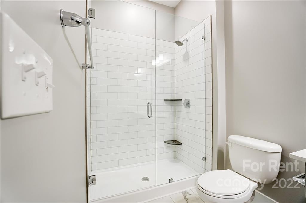 830 Providence Road, Unit 102 Charlotte, NC 28207 - Photo 29 of 31 a bathroom with a shower a toilet and a shower