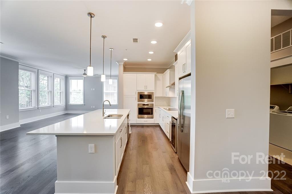 830 Providence Road, Unit 102 Charlotte, NC 28207 - Photo 10 of 31 a view of a kitchen with a sink and refrigerator