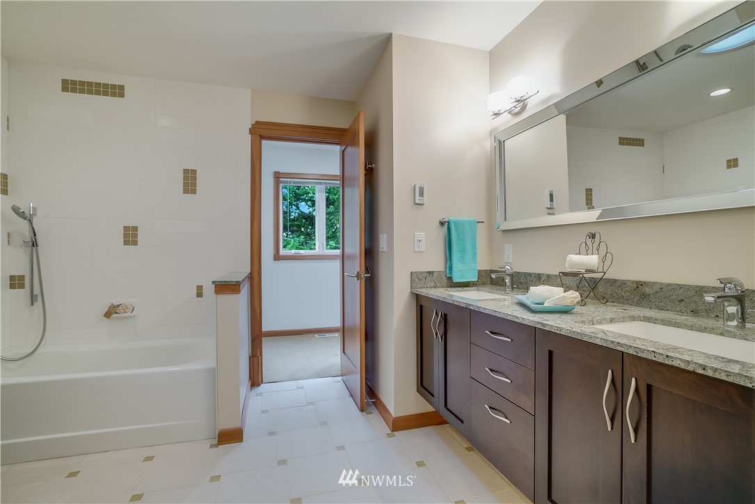 1023 West Ruffner Street Seattle, WA 98119 - Photo 18 of 25 a bathroom with a granite countertop sink mirror bathtub and shower