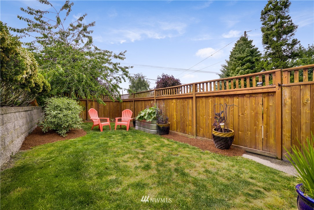 1023 West Ruffner Street Seattle, WA 98119 - Photo 23 of 25 a view of a patio with table and chairs and potted plants with wooden fence