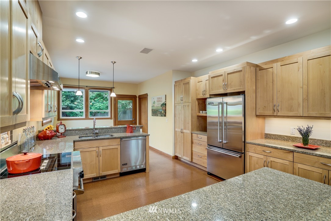 1023 West Ruffner Street Seattle, WA 98119 - Photo 7 of 25 a kitchen with stainless steel appliances granite countertop a sink stove and refrigerator