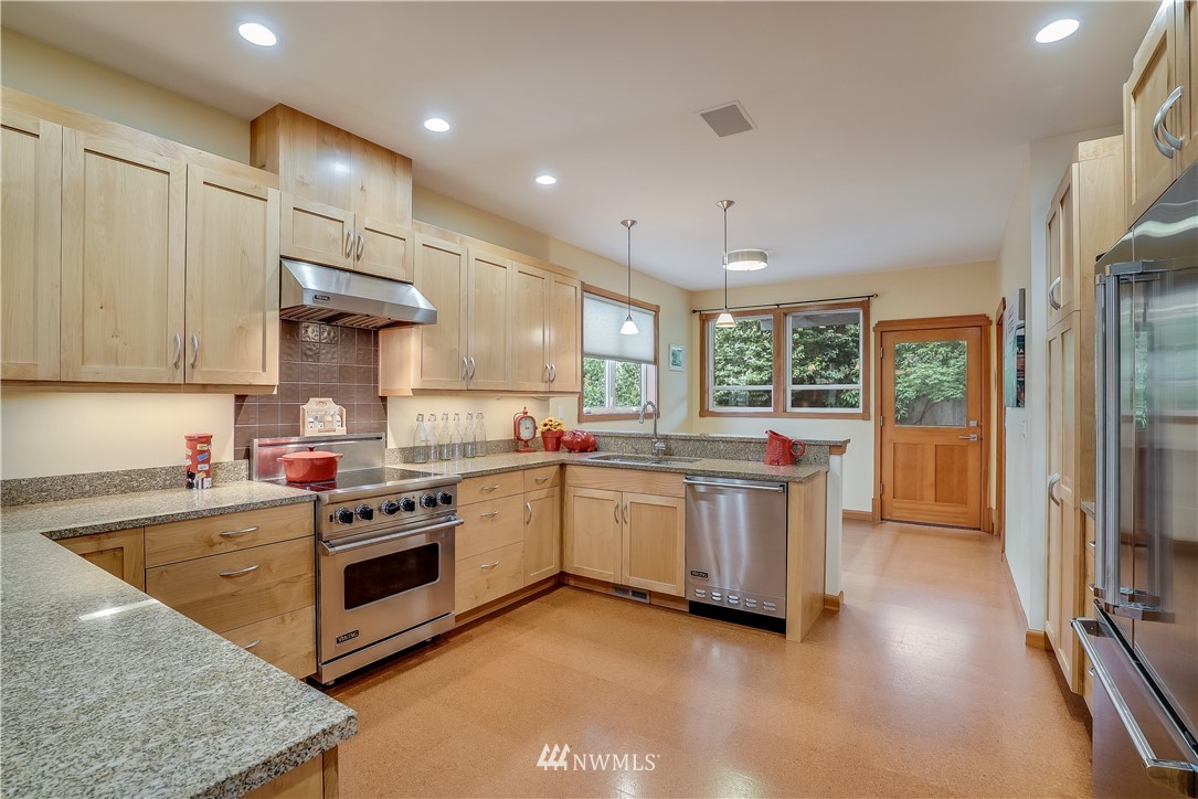 1023 West Ruffner Street Seattle, WA 98119 - Photo 8 of 25 a kitchen with stainless steel appliances granite countertop a stove a sink and a refrigerator