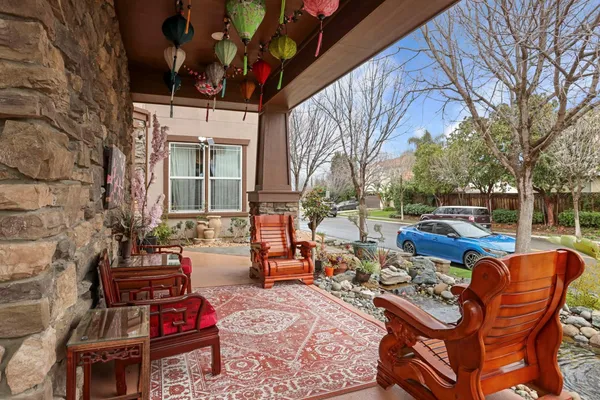 a view of a patio with table and chairs and floor to ceiling window