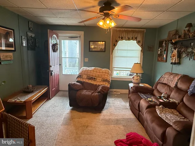 a living room with furniture a dining table and a chandelier
