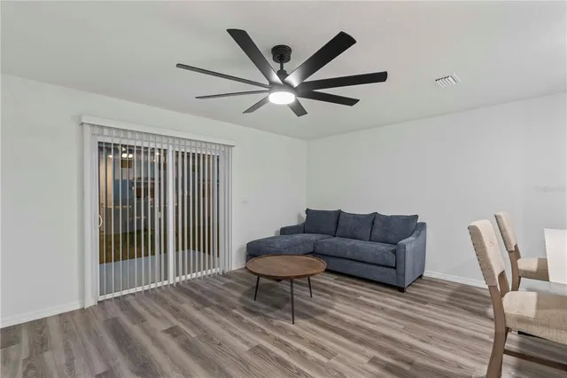 a living room with furniture and a ceiling fan