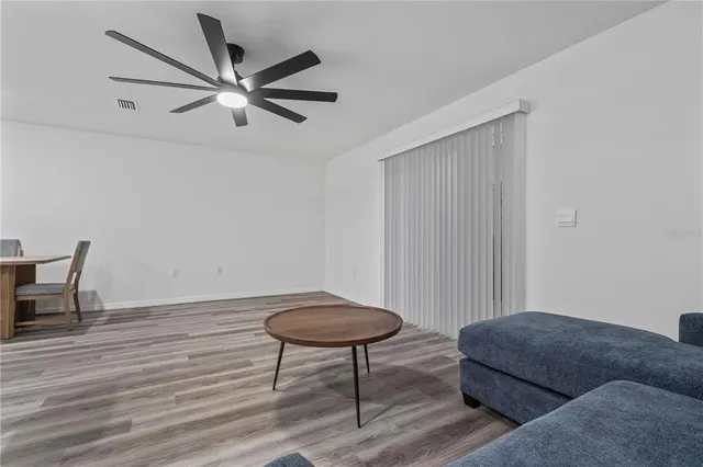 a living room with furniture and a wooden floor
