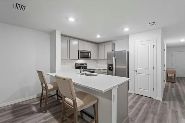 a kitchen with a dining table chairs refrigerator and cabinets
