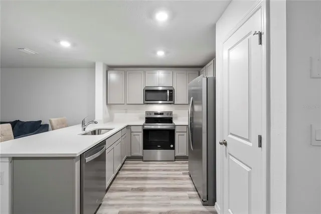 a kitchen with a sink stainless steel appliances and cabinets