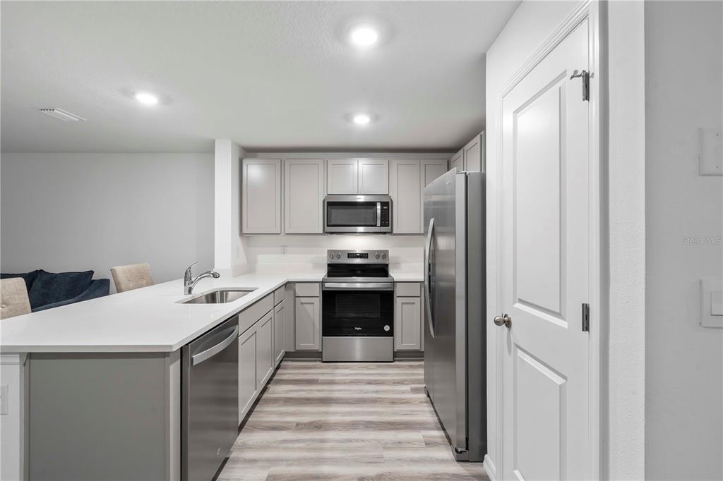 959 Spotted Egret Loop Ruskin, FL 33570 - Photo 21 of 36 a kitchen with a sink stainless steel appliances and cabinets