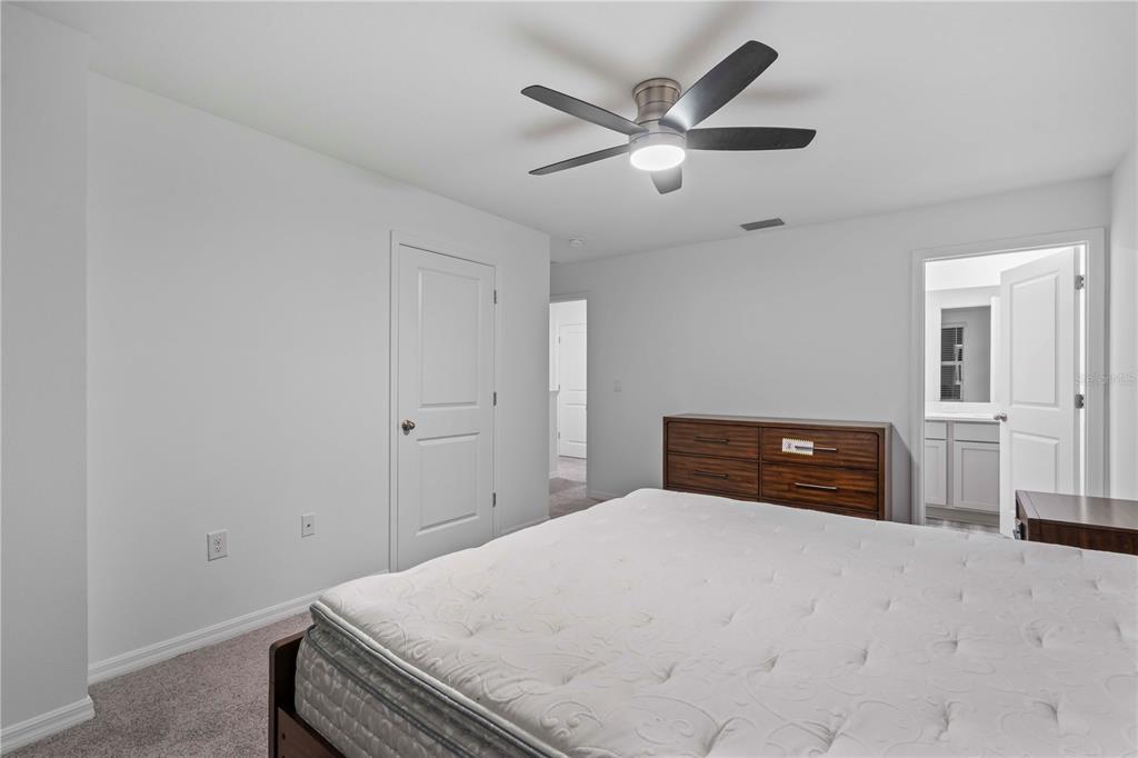 959 Spotted Egret Loop Ruskin, FL 33570 - Photo 27 of 36 a bedroom with a bed and a chandelier
