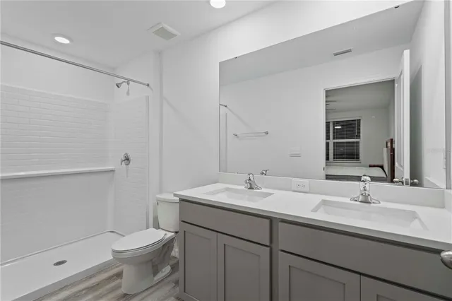 a bathroom with a sink a toilet and shower