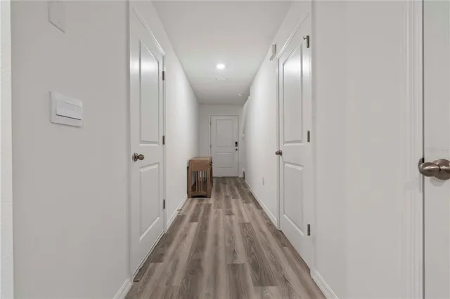 a view of a hallway with wooden floor
