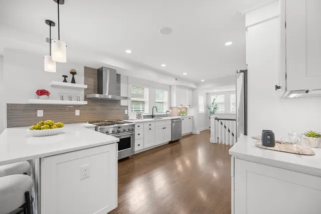 a kitchen with kitchen island white cabinets and white appliances
