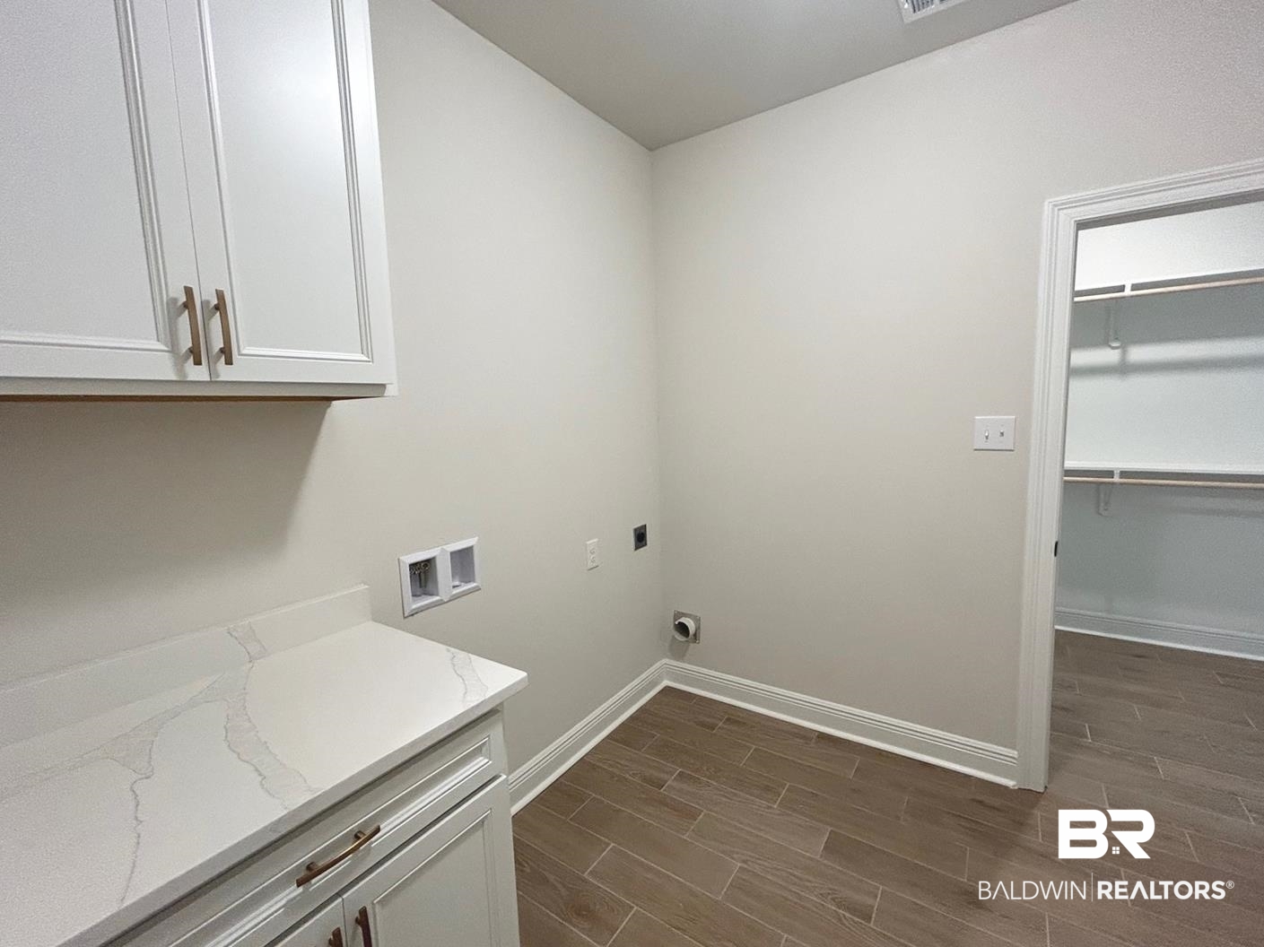 872 Sumter Loop Foley, AL 36535 - Photo 11 of 18 Laundry room with dark wood-type flooring, hookup for a washing machine, electric dryer hookup, and cabinets