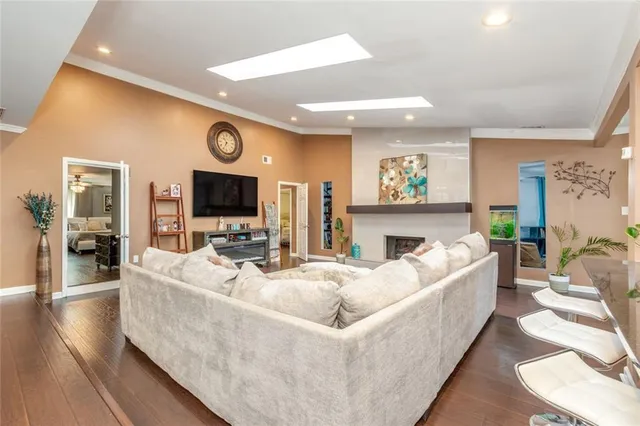 a large kitchen with stainless steel appliances kitchen island a large counter top a stove and a wooden floors