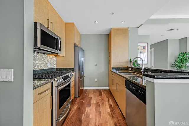 a kitchen with stainless steel appliances a sink dishwasher stove and oven