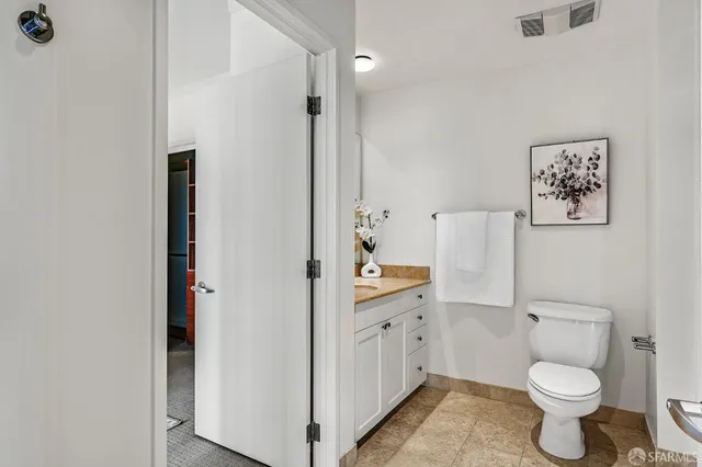 a bathroom with a toilet sink vanity and mirror