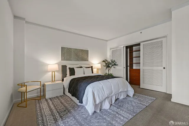 a bedroom with a large bed a potted plant and a rug