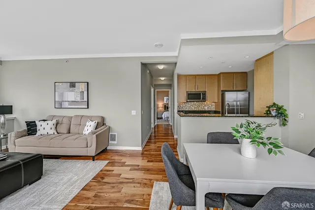 a living room with furniture and a dining table with kitchen view