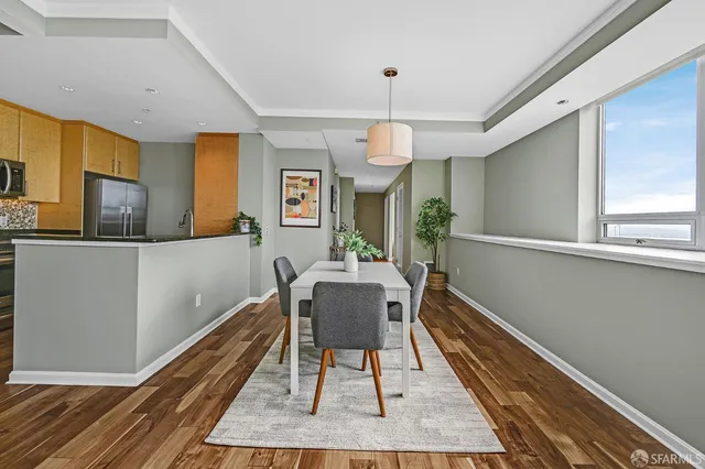 a dining room with wooden floor a chandelier a wooden table and chairs