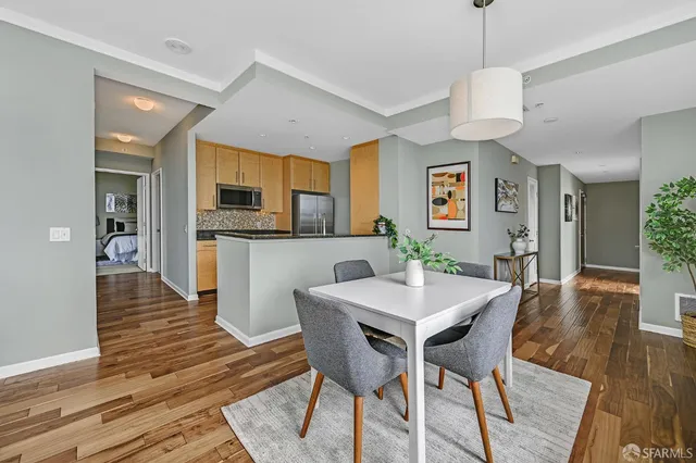 a view of a dining room and livingroom with furniture wooden floor a chandelier