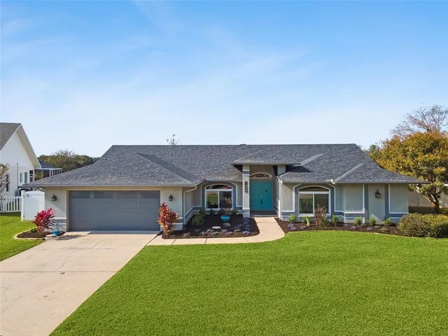 a front view of a house with a garden and plants
