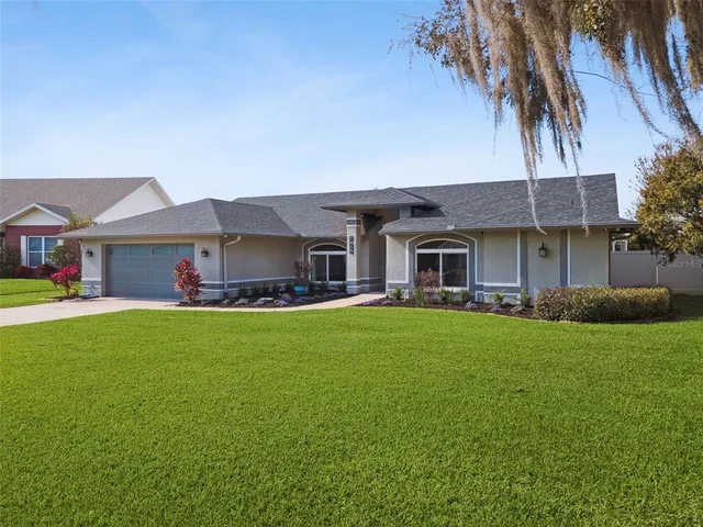 a view of an empty room with a fireplace and a chandelier fan