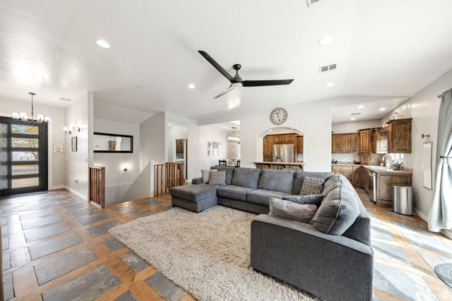 7776 Wagon Road East St. George, UT 84770 - Photo 12 of 76 Living area featuring hanging lights, stone tile floors, arched walkways, and ceiling fan