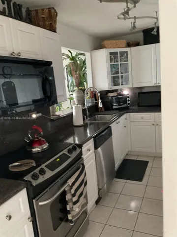 a kitchen with a stove a sink and a microwave