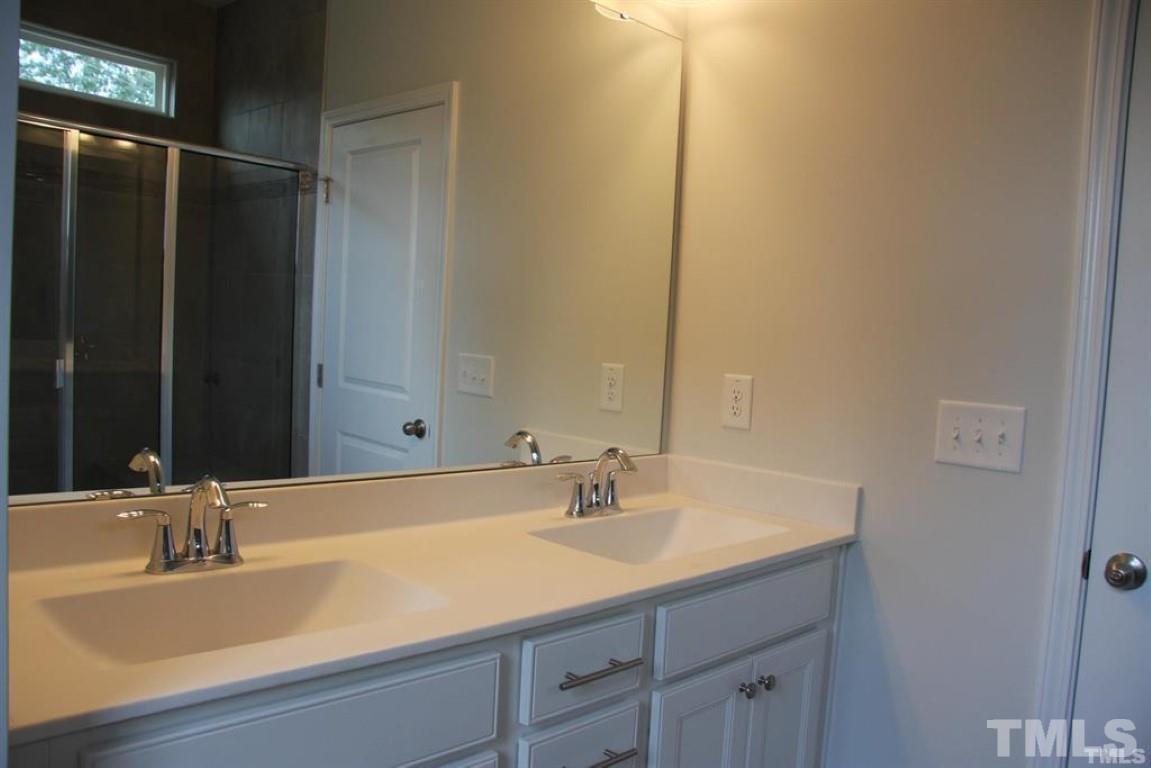 2919 Sunflower Road Apex, NC 27502 - Photo 21 of 34 a bathroom with a sink and a mirror