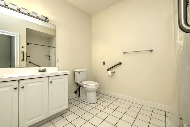 a bathroom with a toilet a sink and a mirror