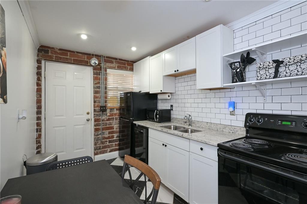 24 Daniel Street Southeast, Unit 6 Atlanta, GA 30312 - Photo 4 of 14 a kitchen with stainless steel appliances a stove a sink a refrigerator a cabinets and wooden floor