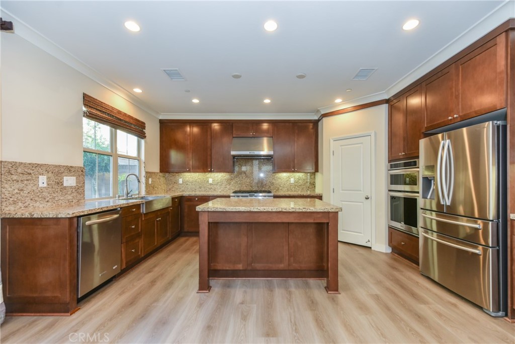 67 Elmdale Irvine, CA 92620 - Photo 10 of 39 a large kitchen with stainless steel appliances granite countertop a stove and a refrigerator